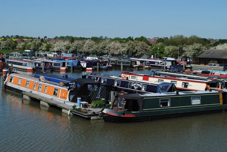 a number of boats in a body of water, by Dave Allsop, shutterstock, railing along the canal, springtime morning, very very wide shot, female looking