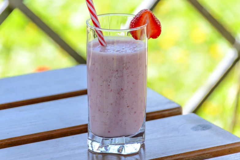 a drink sitting on top of a wooden table, by Juan O'Gorman, pixabay, strawberry ice cream, milky white skin, hay, milkshake