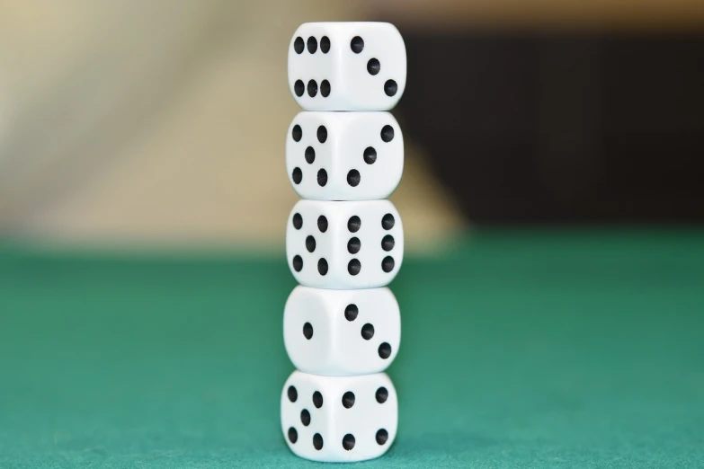 a stack of four dice sitting on top of a green table, dau-al-set, 24 35 mm, a tall, white, long-shot