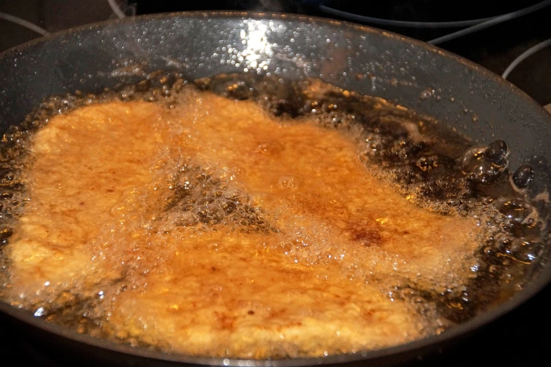 a frying pan filled with food on top of a stove, flickr, maple syrup fluid, battered, closeup - view, sfw