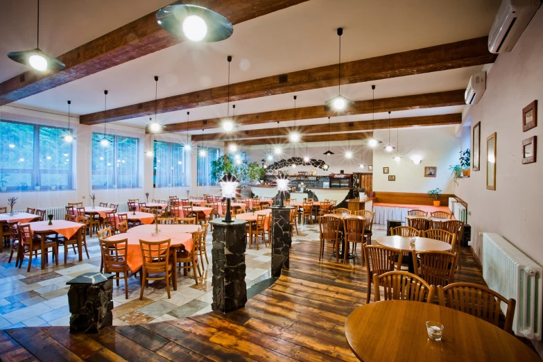 a dining room filled with lots of tables and chairs, by Aleksander Gierymski, shutterstock, big wooden club, cozy and peaceful atmosphere, gradins view, commercial photo