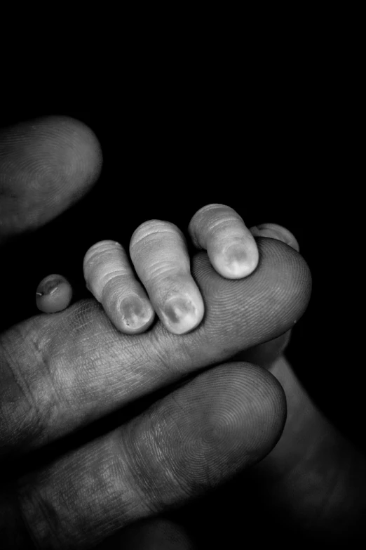 a close up of a person holding a finger, a black and white photo, maternal, hunger, different sizes, high details photo