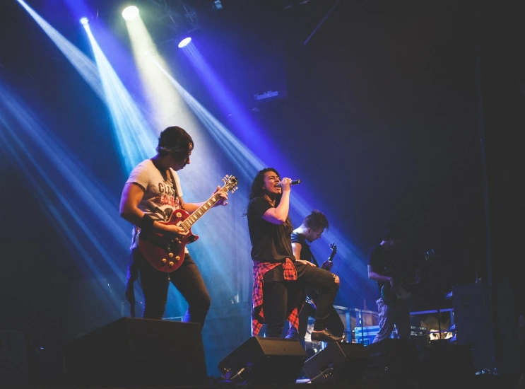 a group of people standing on top of a stage, a picture, by Amelia Peláez, antipodeans, band playing, dramatic lighting and colors, gemma chen, in 2 0 1 5