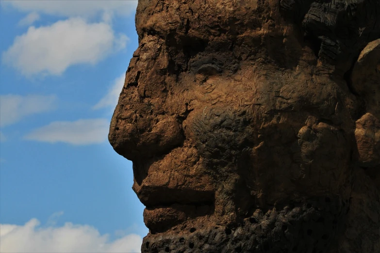 a close up of a statue of a man's face, a statue, by Jon Coffelt, flickr, surrealism, lava rock, view from the side”, gigantic man head, face made out of clouds