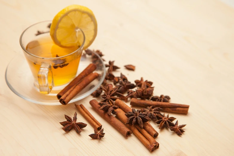 a cup of tea sitting on top of a wooden table, spices, istockphoto, star, lemon