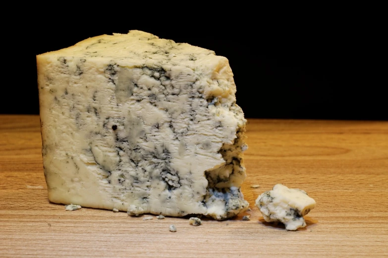 a piece of cheese sitting on top of a wooden table, renaissance, blue silver and black, high quality product image”, a daub of cold blue, insanly detailed