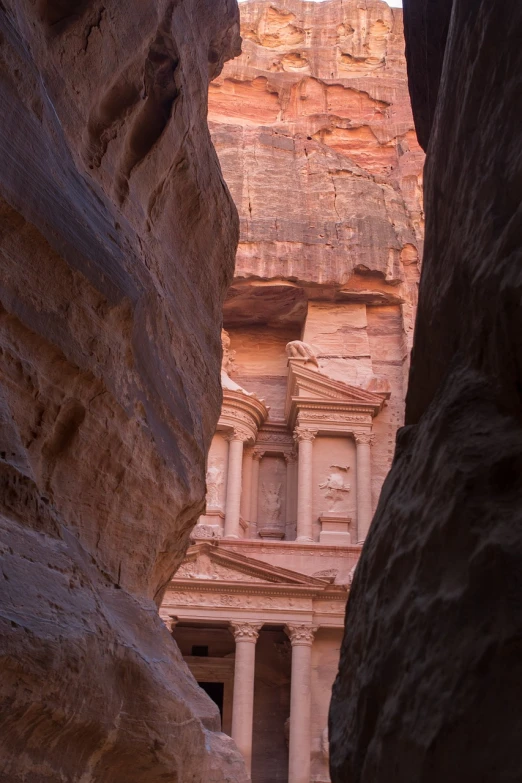 a person riding a horse through a narrow canyon, a portrait, architecture carved, sandstone, front photo, very accurate photo