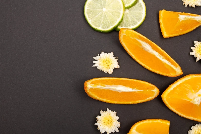 sliced oranges, limes, and flowers on a black surface, minimalism, candy treatments, elena masci, half moon, istock