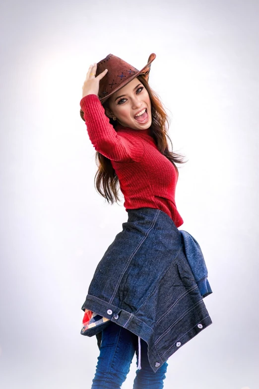 a woman in a red sweater and a denim skirt, a stock photo, shin hanga, wearing cowboy hat, playful pose of a dancer, outfit photo, wide angle studio shoot