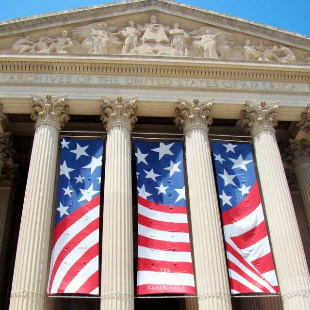 a large american flag hanging from the side of a building, neoclassicism, banners, national archives, an ancient, display