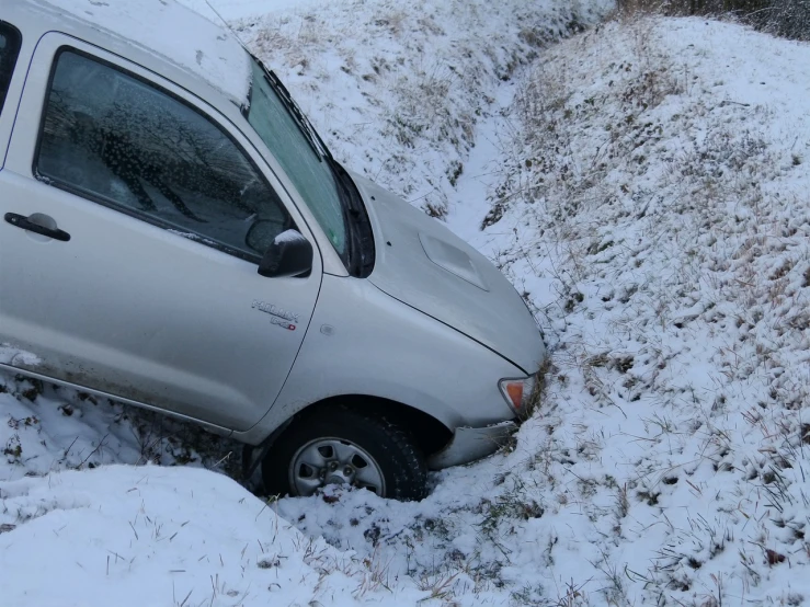 a car that is sitting in the snow, a photo, reddit, auto-destructive art, stuck in the ground, traffic accident, in the hillside, high res photo