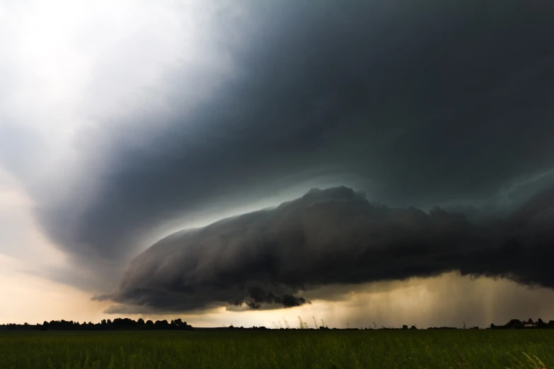 a large black cloud looms over a green field, by Andrew Domachowski, extreme low angle shot, hell storm, in profile, hull