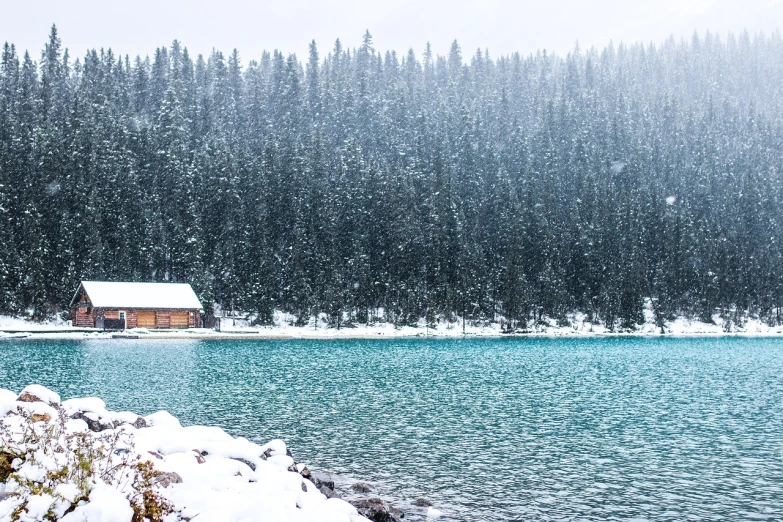 a cabin sitting on top of a snow covered lake, a photo, by Richard Carline, shutterstock, fine art, puddles of turquoise water, slightly pixelated, colour photo, stock photo