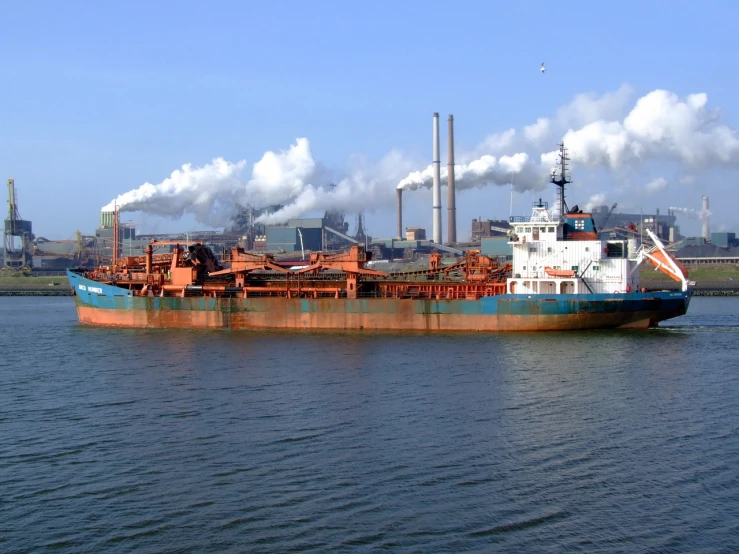 a large boat floating on top of a body of water, by Albert Bertelsen, flickr, figuration libre, chemical plant, brown and cyan color scheme, utilitarian cargo ship, stock photo