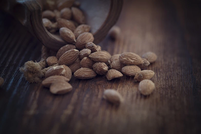 a wooden table topped with nuts on top of it, a tilt shift photo, by Artur Tarnowski, retro effect, shot on canon eos r 5, close up shot of an amulet, highly detailed product photo