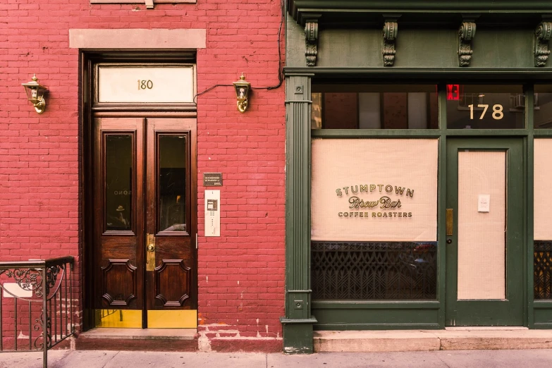 a brown fire hydrant sitting in front of a red brick building, by Nyuju Stumpy Brown, small hipster coffee shop, symmetrical doorway, 1 8 8 0 s, nighthawks