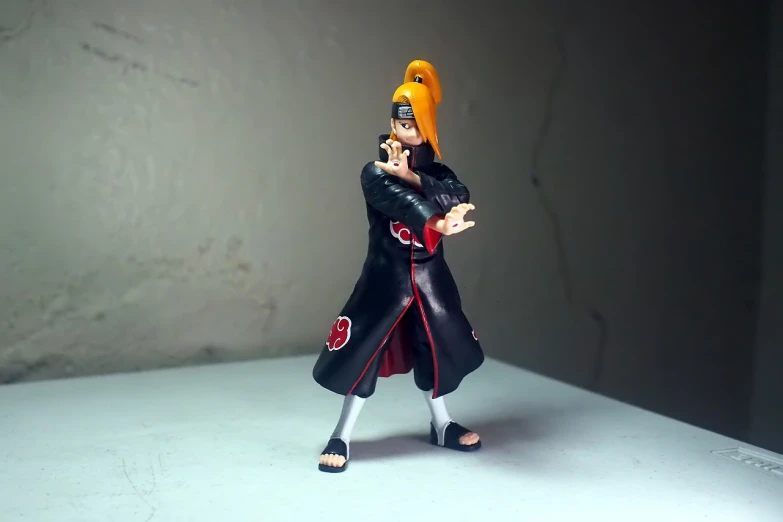 a close up of a toy figure on a table, shin hanga, pain from naruto, full body black and red longcoat, portrait mode photo, uzumaki