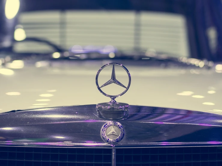 a close up of a hood ornament on a car, by Matthias Weischer, pexels, arabesque, mercedez benz, background is a low light museum, 7 0 s photo, stock photo