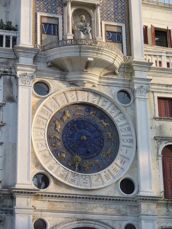 a large clock on the side of a building, by Antonio de la Gandara, baroque, venice, photo taken in 2018, libra symbol, sunny morning