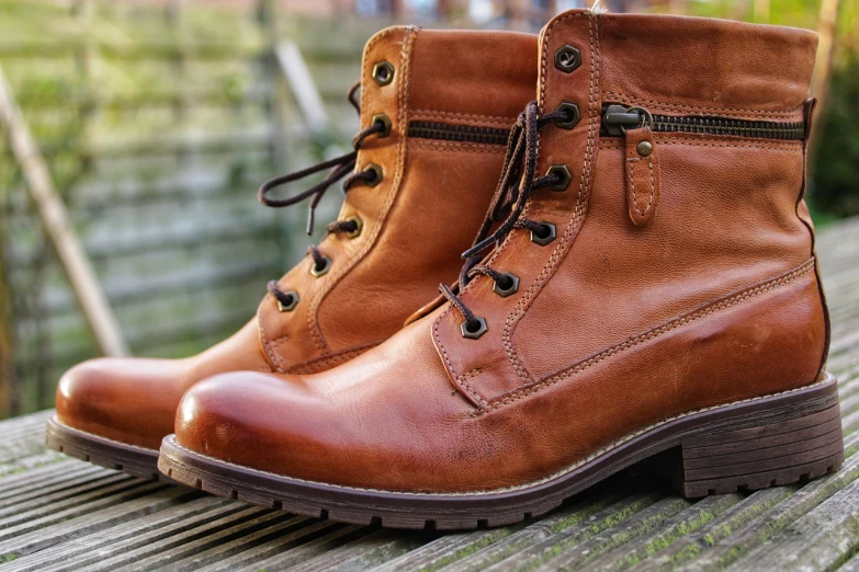 a pair of brown boots sitting on top of a wooden bench, a portrait, by Jan Tengnagel, pixabay, 🐝👗👾, caramel. rugged, zippers, side view close up of a gaunt