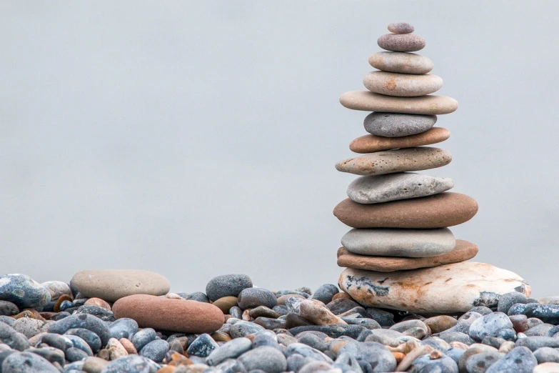a stack of rocks sitting on top of a rocky beach, unsplash, minimalism, istockphoto, totem pole, background image, pebbles
