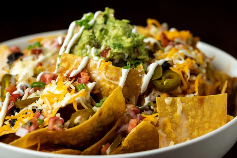 a bowl of nachos topped with cheese and toppings, by Joe Bowler, sombrero, closeup - view, 4k food photography, usa-sep 20