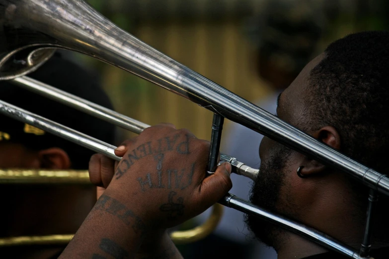 a close up of a person playing a trombone, by Paul Davis, flickr, heavy body modification, bayou, jamaica, repetitiveness