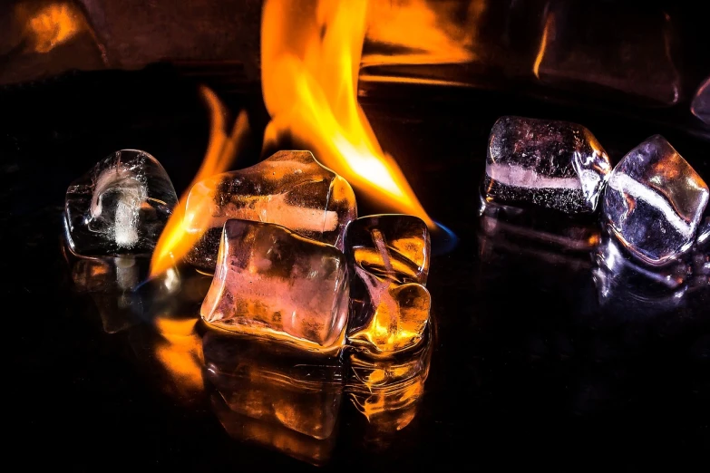 a group of ice cubes sitting on top of a table, a picture, by Tom Carapic, pexels, process art, big flames, old fashion, looking hot, fire reflection
