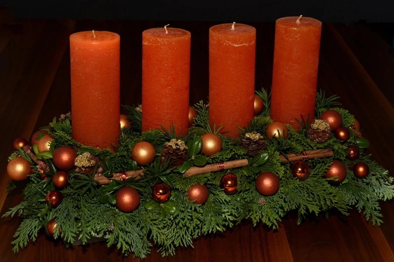 a group of candles sitting on top of a wooden table, a photo, orange color scheme, pine, very ornate, - h 7 0 4