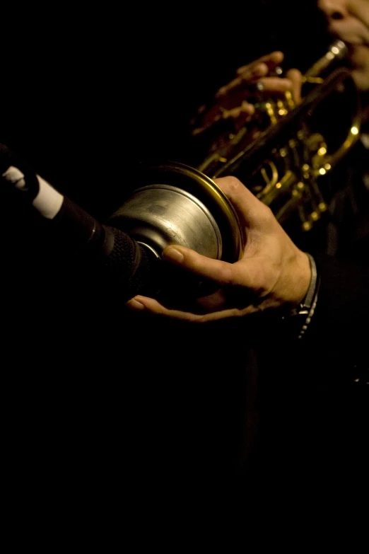 a close up of a person playing a trumpet, by Thomas Häfner, flickr, purism, paris 2010, holding a tin can, saxophones, low-light