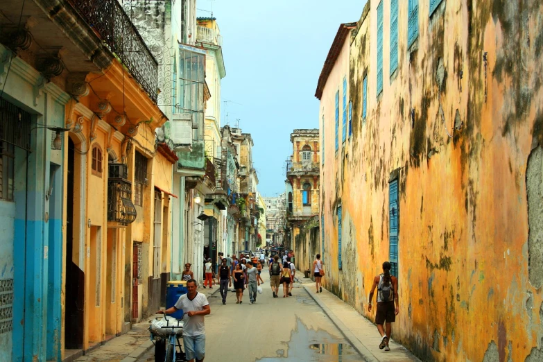 a group of people walking down a narrow street, by Ken Elias, flickr, cuban setting, wide open city ”, golden hour”, city of pristine colors
