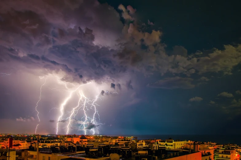 a lightning storm over a city at night, by Erik Pevernagie, thunderstorm in marrakech, storm at sea, highly saturated, thunderclouds