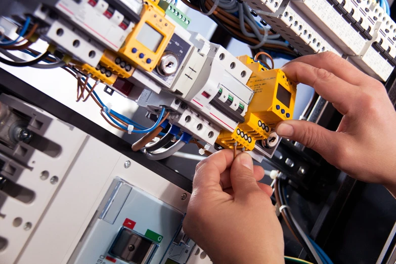 a close up of a person working on electrical equipment, a stock photo, shutterstock, very accurate photo, installation, professionally done, full colour