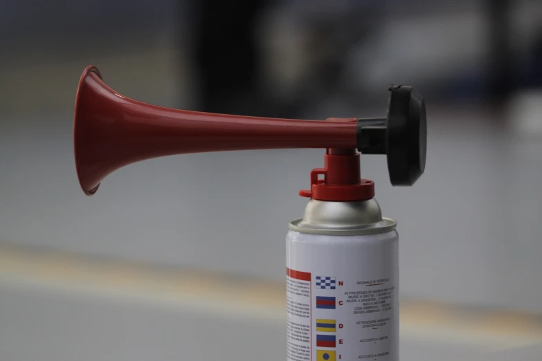 a red horn sitting on top of a white table, a picture, shutterstock, mechanics, fume, inflatable, cans