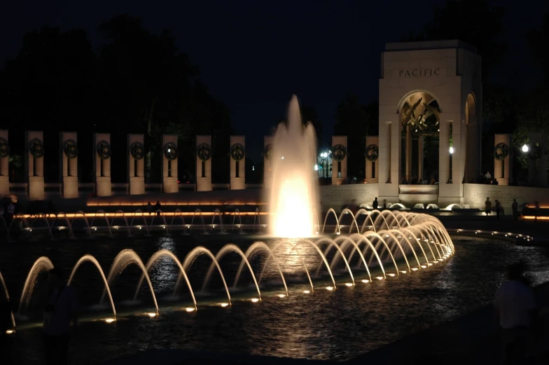 a group of people standing in front of a fountain, set at night, arches, patriotic, wikimedia