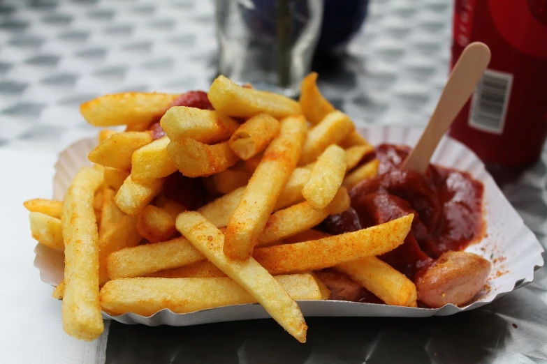 a basket of french fries with ketchup and ketchup, a picture, pexels, photorealism, chorizo sausage, square, silver, eating outside