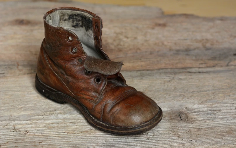 a brown shoe sitting on top of a wooden floor, a portrait, pixabay, photorealism, tattered leather coat, ww 2, photo of poor condition, some wrinkled