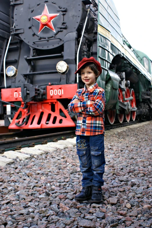 a young boy standing in front of a train, inspired by Otto Pilny, trending on pixabay, russian clothes, wearing plaid shirt, jeans and boots, young tsar