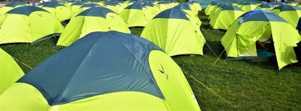 a group of tents sitting on top of a lush green field, a photo, pixabay, with fluo colored details, tournament, 2 0 2 2 photo, avian