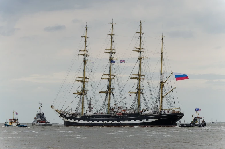 a large boat floating on top of a body of water, a portrait, by Serhii Vasylkivsky, shutterstock, romanticism, three masts, parade, photo taken on a nikon, naval background