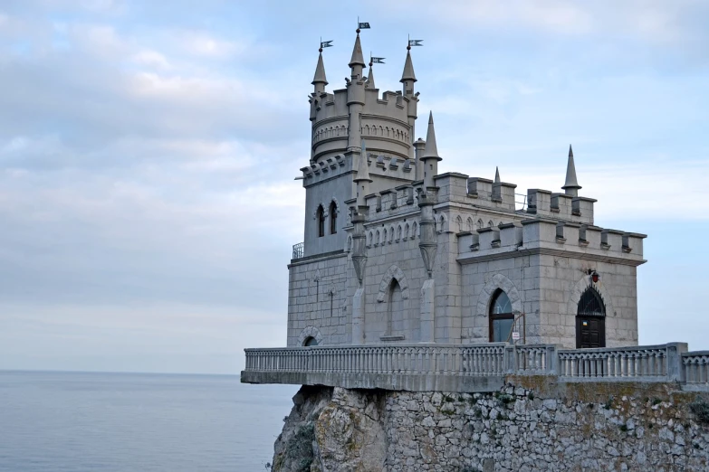 a castle sitting on top of a cliff next to the ocean, a photo, by Serhii Vasylkivsky, shutterstock, neo - gothic architecture, front side, high details photo, russian