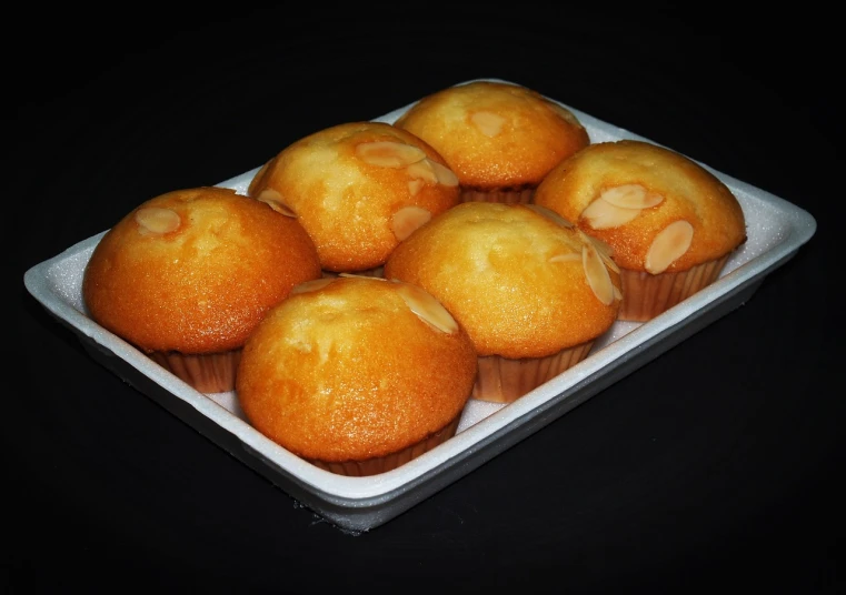 a close up of a plate of muffins on a table, by Amédée Ozenfant, on black background, very realistic looking, oven, vanilla