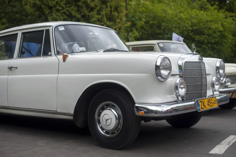 a white car is parked in a parking lot, a photo, pixabay, arabesque, classic chrome, mercedes, stock photo, restored color