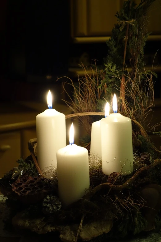 a group of white candles sitting on top of a table, a photo, by Paul Emmert, shutterstock, baroque, christmas night, vertical orientation, jungian symbols of winter, unedited