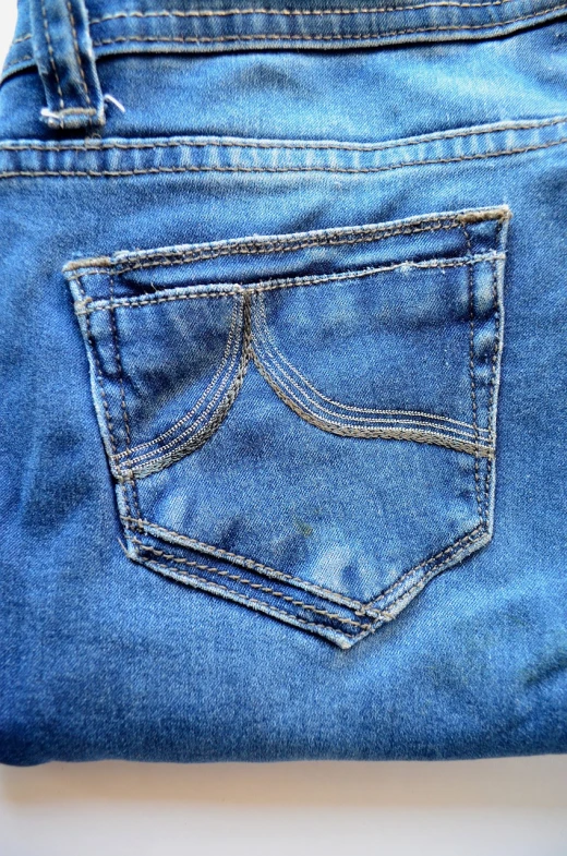 a pair of blue jeans sitting on top of a table, a macro photograph, buttshape, closeup photo, sunny morning, pockets