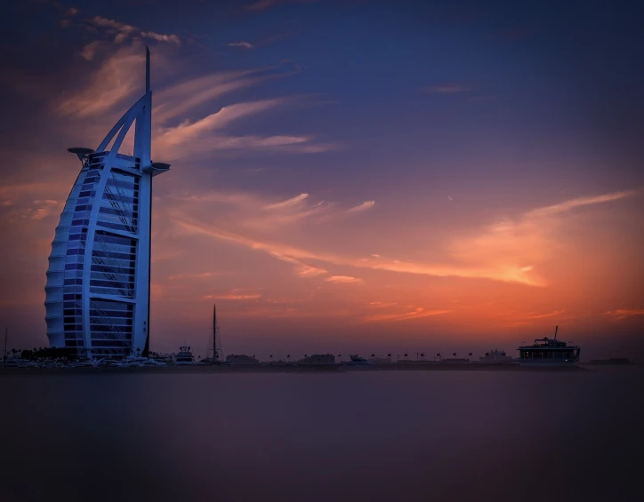 a tall building sitting on top of a sandy beach, by Erik Pevernagie, pexels contest winner, romanticism, dubai, red sunset, the photo was taken from a boat, matte painting”