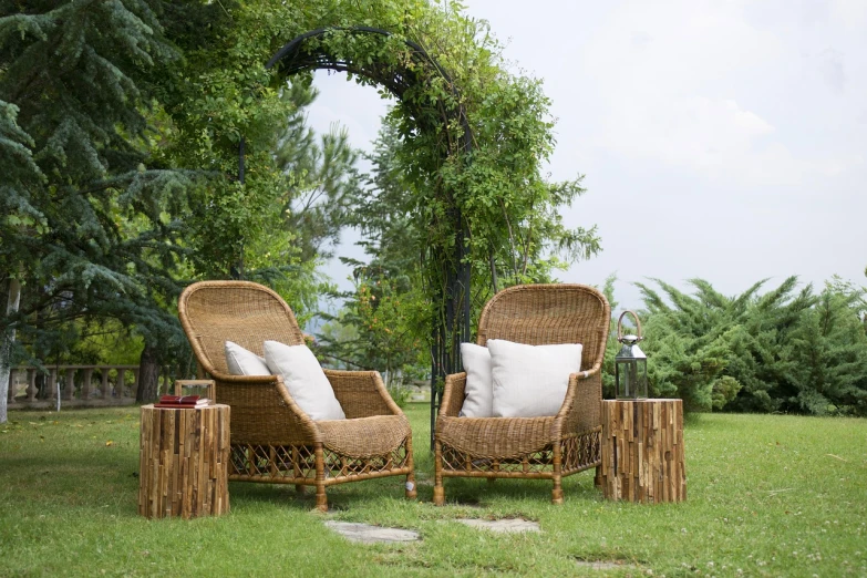 a couple of chairs sitting on top of a lush green field, a portrait, shutterstock, wicker art, garden at home, in the tropical wood, high quality product image”