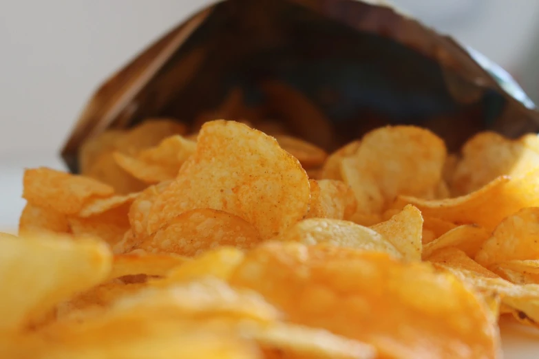 a bag of potato chips sitting on top of a table, a picture, pexels, photorealism, istockphoto, close-up shot from behind, closeup 4k, potato skin