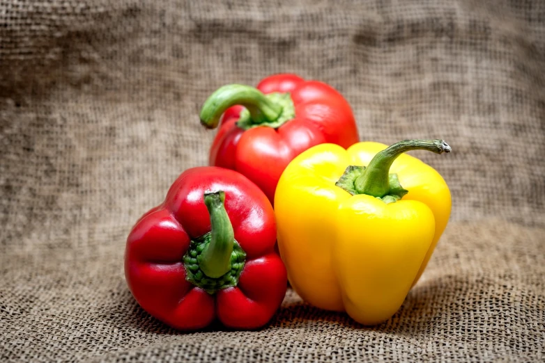 three peppers sitting next to each other on a table, a portrait, pixabay, avatar image, foodphoto, linen, red yellow