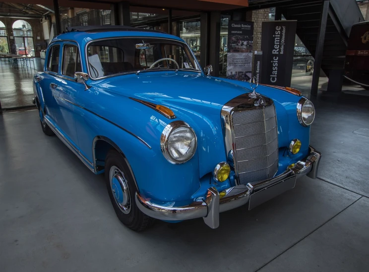 a blue car is parked in a garage, by Frederik Vermehren, flickr, mercedez benz, preserved historical, albuquerque, on display in a museum